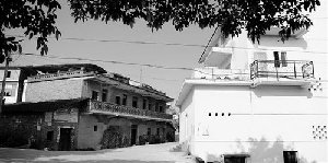 雷政富家新盖的房子紧挨着老宅。本报记者 黄葆青