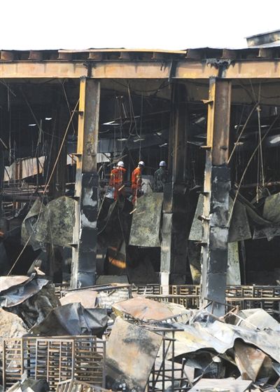 6月6日，火灾事故现场，几名消防队员在被烧毁的厂房内勘查。 新京报记者 吴江 摄