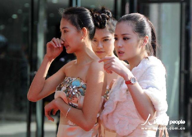 2013年11月16日9时，在江西九江一车展现场，寒风中穿着露肩礼服的礼仪小姐冻得只打喷嚏。CFP/CFP