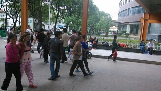 医院院内“人满为患”，石凳石桌上坐满了疲惫的患者和家属