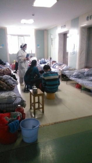 电梯旁的走廊成了临时病房，对于着急入院的患者来说，能住上走廊已经算是“万幸”。医生们就在简陋的电梯旁完成对患者的输液、抽血、以及骨穿等工作。