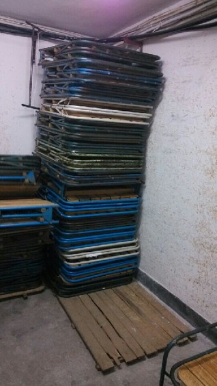 工作人员将归还回来的床铺简单折叠后继续租借给下一波病人。