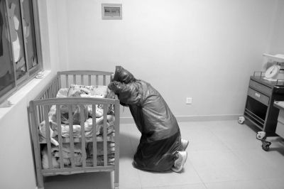 身披雨衣、脸戴口罩的父亲,把女儿放进“弃婴岛”后突然跪地。