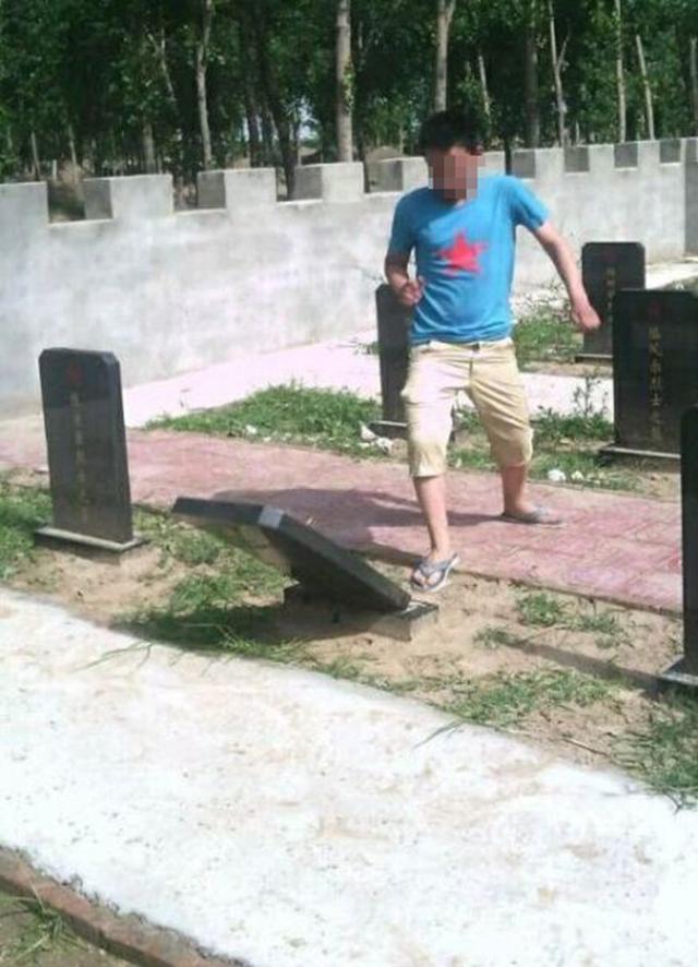 少年将烈士墓碑踢倒。