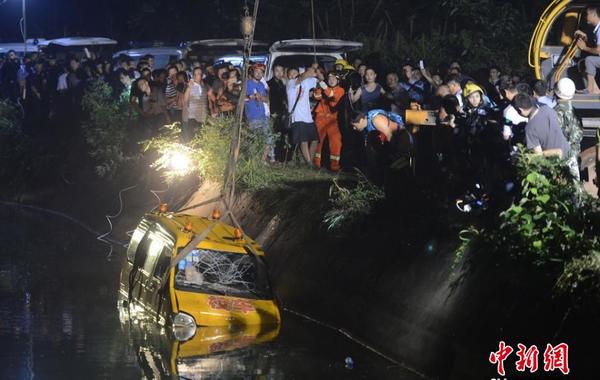 7月10日下午5时许，湖南湘潭市雨湖区响塘乡金桥村乐乐旺幼儿园所属园车，在送幼儿回家途中，途径湘潭市交界的长沙市岳麓区干子村时，翻入水库。此事故共致11人遇难，包括8名幼儿和3位成人。图为三位打捞人员正在将绳索捆绑于起重机上拉出事故车辆。