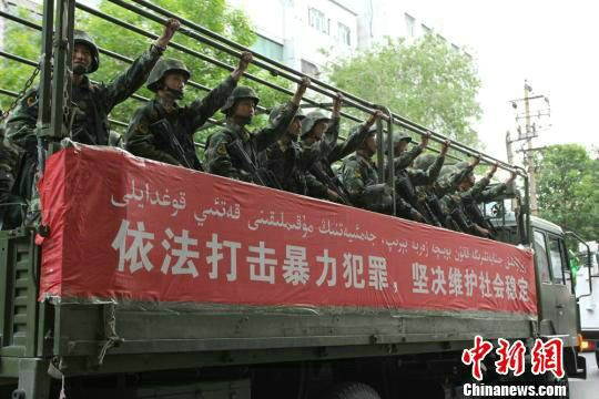 资料图：5月23日下午，新疆首府乌鲁木齐市举行誓师大会，展示反恐决心。武警车辆通过每个路口高喊口号。