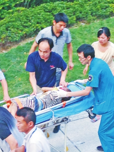 救护人员用担架将男童送上救护车