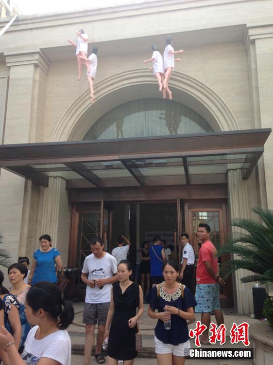 浙江金华一楼盘打折销售 业主拉横幅挂充气娃娃抗议