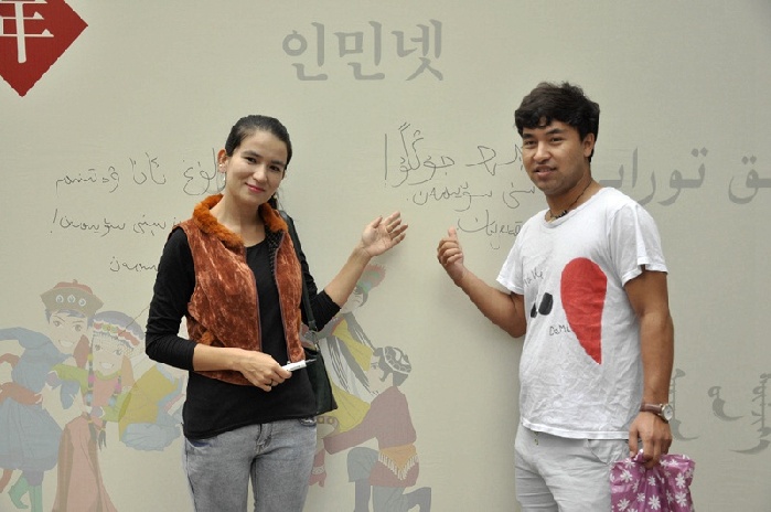 来自中央民族大学的维吾尔族学生在留言板前合影留念。（人民网杨丽娜 摄）