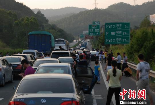 图为梅河高速段出现拥堵司机及乘客都纷纷下车“休息”。　颜新阳摄