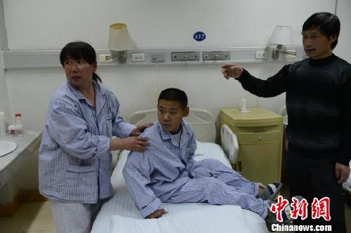 手术前，段淑花给儿子整理衣服（周明政摄影）　周明政摄