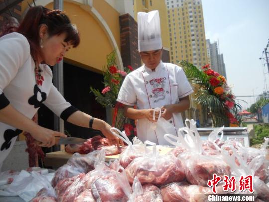 “新羊肉哥”宋文龙(右)分装供免费发放的羊肉。　门杰丹 摄