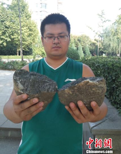 陈钾展示被劈开的坚硬鹅卵石断面。　门杰丹 摄
