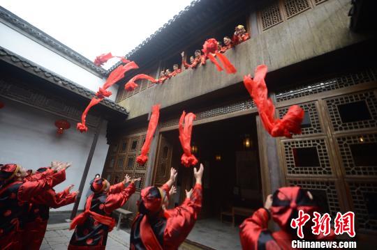 图为新娘在小姐秀楼上抛绣球。　孟德龙 摄