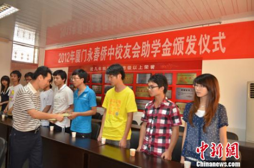 资料图：图为厦门永春华侨中学校友会会长陈坚扬为永春华侨中学贫困学子颁发助学金。　梁白瑜 摄