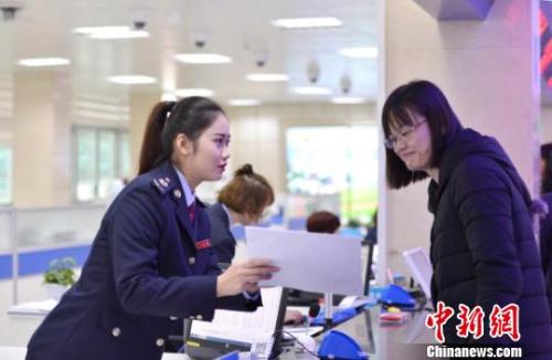 资料图:税务人员为纳税人讲解相关涉税事项。王旺旺 摄 资料图:税务人员为纳税人讲解相关涉税事项。王旺旺 摄