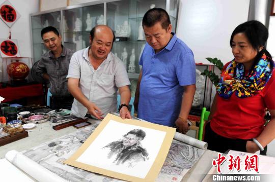 厦门大学诏安画派研究中心副主任沈瑞生展示百岁老人书画作品。　张金川 摄