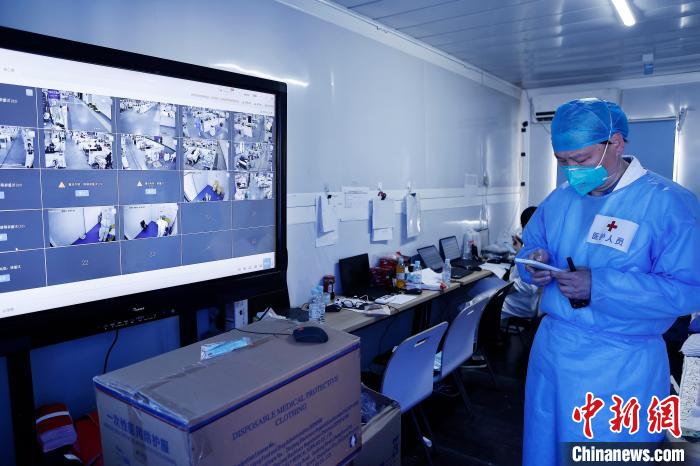 方舱医院外，医生在不断确定首批康复者的身体各项指标。　殷立勤 摄