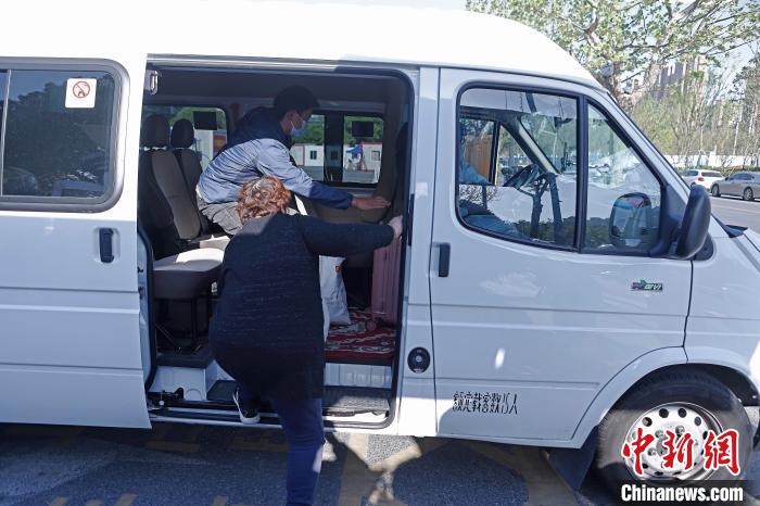 康复者带着自己的行李上车准备回家。　殷立勤 摄