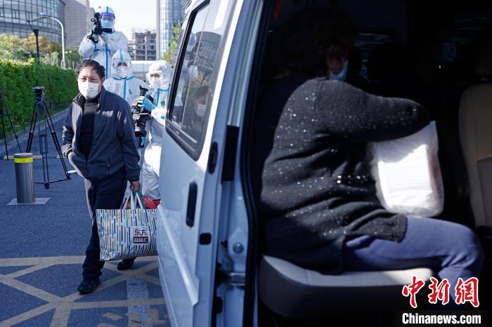 康复者带着自己的行李准备上车回家。　殷立勤 摄