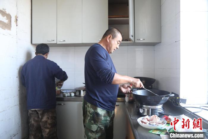 图为于文鹏和陈玉峰在塔房内准备饭菜。　何康红 摄