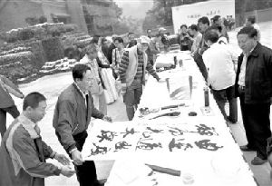 昨日，八大处公园新游客服务中心广场，一群书画家在进行书画创作。当日，第26届北京八大处重阳游山会开门迎客。新京报记者 浦峰 摄