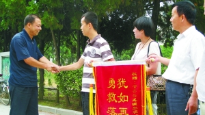 获救少年家属给“的哥”马俊麟送锦旗。