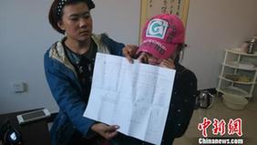 图为徐晓云（戴帽子）展示诊断结果。　刘洋　摄