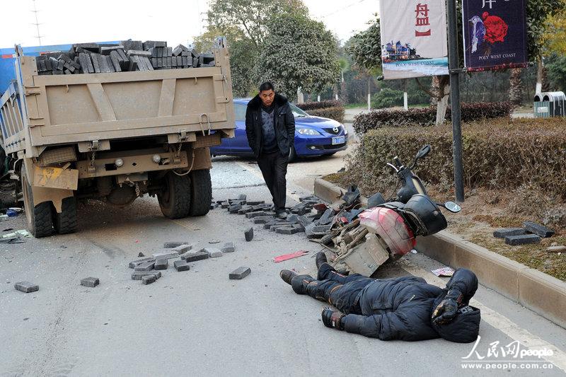 车祸现场，摩托车司机无法动弹。雨天/CFP