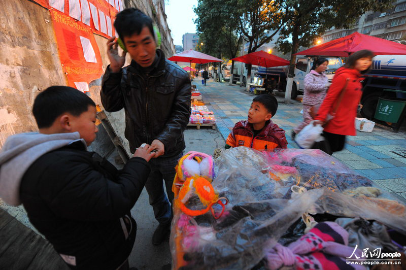 傍晚6时19分，一个顾客花4块钱买走了一个耳套，李鸿昆在一边连问：“叔叔，热和不？”CFP