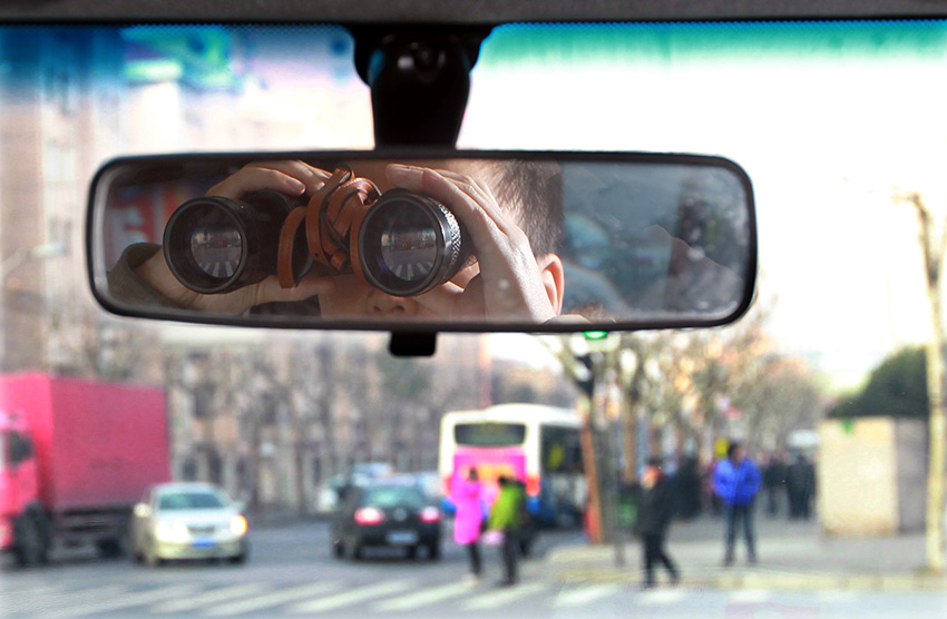 反扒队员李某在用望远镜观察公交车站情况（1月16日摄）。新华社记者 凡军 摄