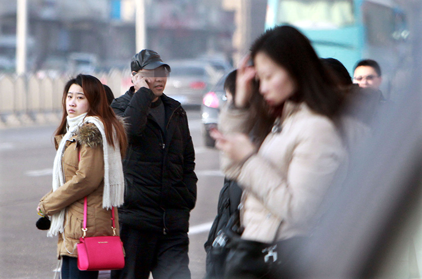 反扒队员雷某（戴帽子者）在公交车站蹲守（1月16日摄）。新华社记者 凡军 摄