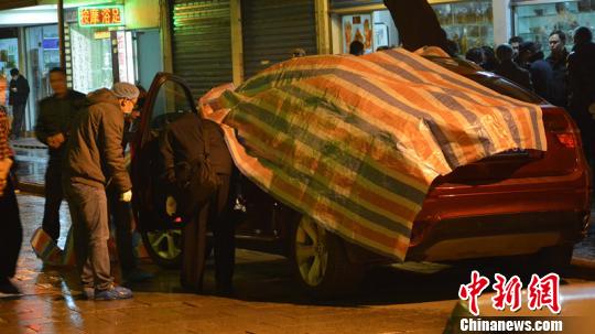 图为警方正在调查涉事车辆。　李果　摄src=