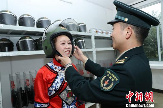 图为婚礼结束后，一位新郎带新娘体验防暴头盔。　周晓星 摄