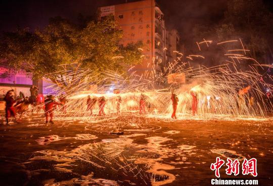舞龙人手持龙灯穿巡于火花之中。　姜永宁　摄